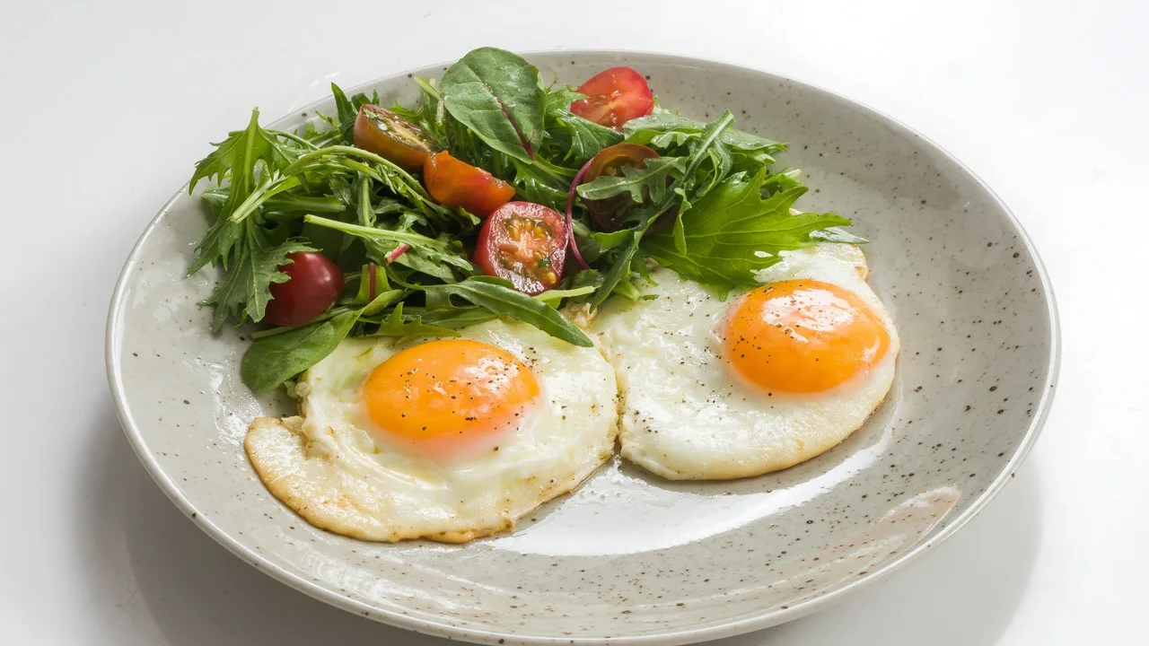 Miksi on suositeltavaa lisätä etikkaa pannulle munia paistaessa ja mikä on sen tarkoitus?